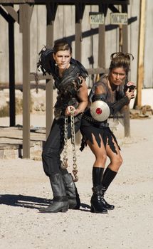 Tough science-fiction women in costumes with weapons.