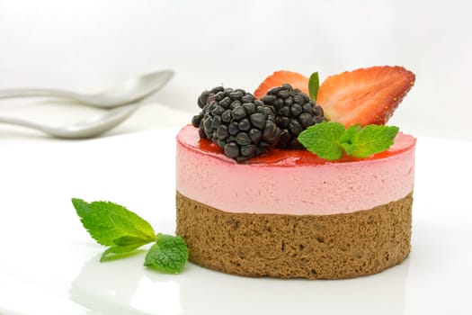 Chocolate and strawberry cake decorated with mulberries and mint leaves