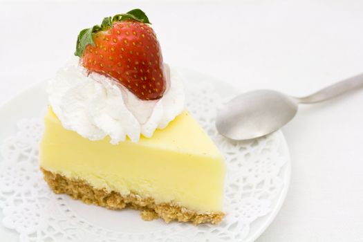 Cheesecake decorated with whipped cream and strawberry