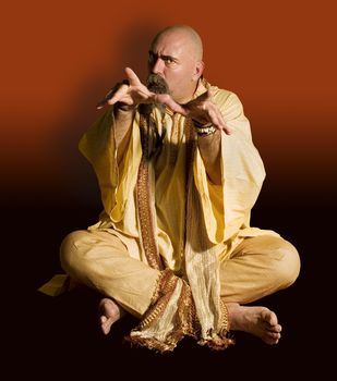 Funny guru sitting lotus style casts an evil spell.