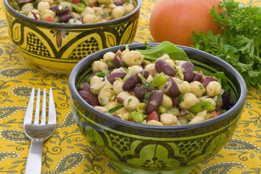 chickpeas and red bean salad served in typical morrocan bowls on a mediterranean tablecloth