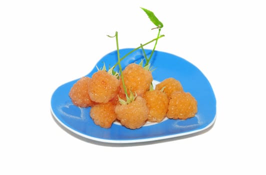 Yellow raspberry on the blue plate isolated on the white. 