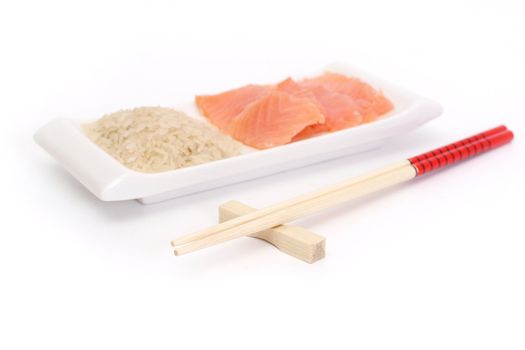 Chinese chopsticks and plate with rice and raw red fish