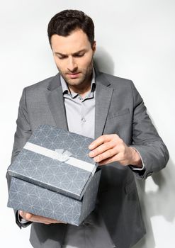 Office clerk with gift box on gray background