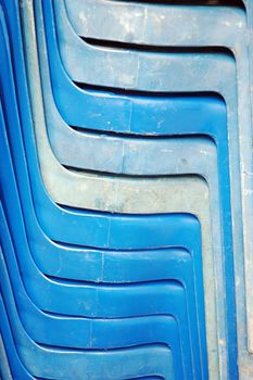 pile of old blue plastic chairs