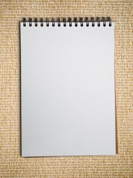 white blank note book on Light brown fabric background