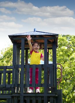 happy little girl on wooden tower playground