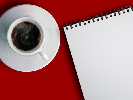 White cup of hot coffee and white notebook on red background