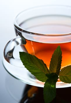 Cup of tea with mint leaf on a saucer