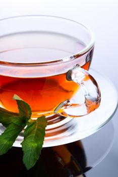 Cup of tea with mint leaf on a saucer