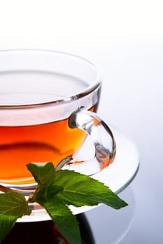 Cup of tea with mint leaf on a saucer
