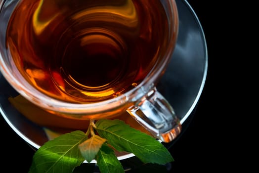 Cup of tea with mint leaf on a saucer