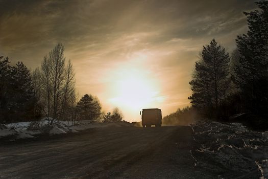 Lorry in the late evening on a background of the coming sun