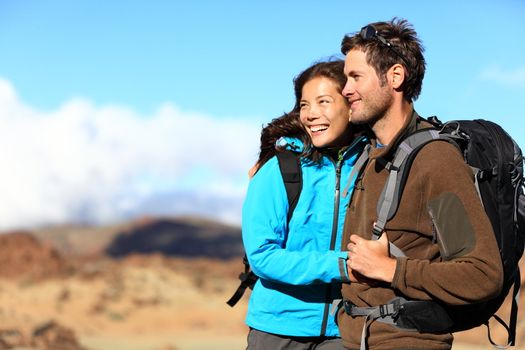 Hiking couple looking at view smiling happy. Young beautiful multiracial couple hikers in their twenties on hike.