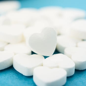 Pills as a heart on blue background