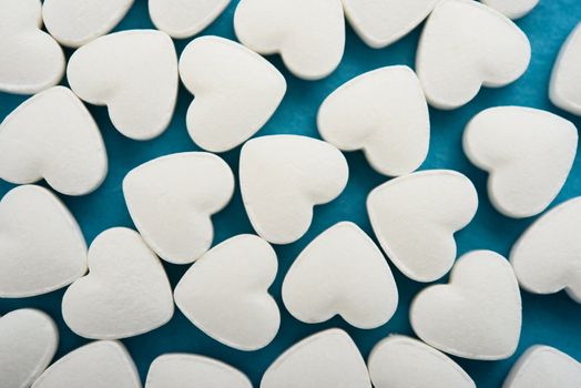 Pills as a heart on blue background