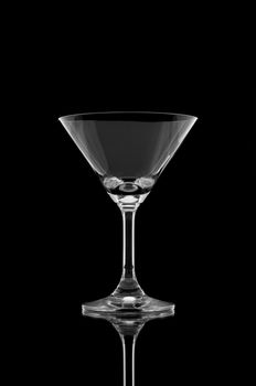 Empty cocktail glass on black background and reflect