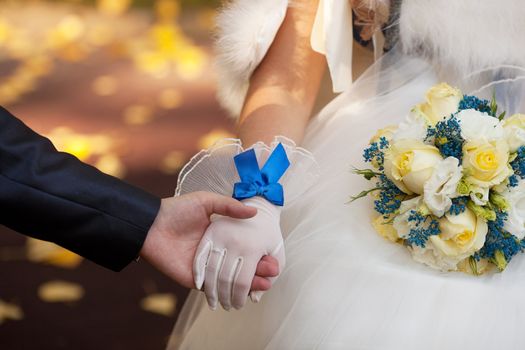 Wedding bouquet. The groom holds the hand of the bride