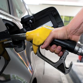 pumping gasoline on a black car in station