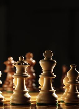 View from behind the white pawns on a chess board