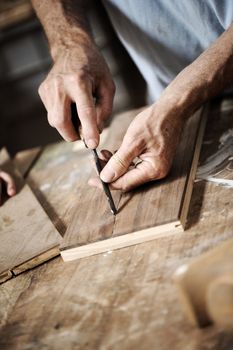 hands of the craftsman carve a bas-relief with a gouge