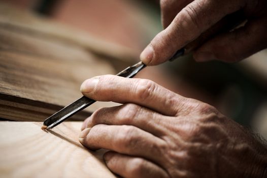 hands of the craftsman carve a bas-relief with a gouge