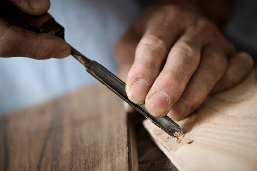 hands of the craftsman carve a bas-relief with a gouge