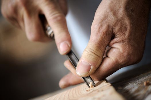 hands of the craftsman carve a bas-relief with a gouge