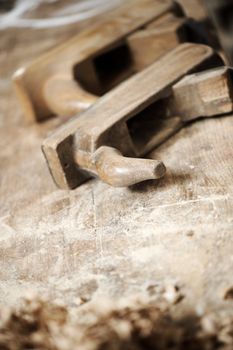 a work table of a carpenter with two hand planers and a pile of wood chips