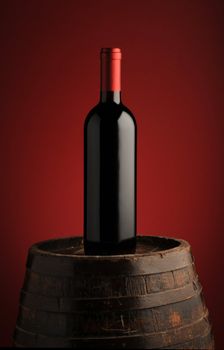 red wine bottle on wodden barrel