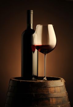 red wine bottle and wine glass on wodden barrel