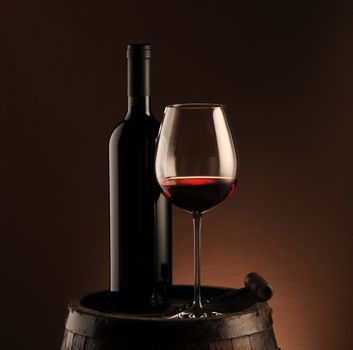 red wine bottle and wine glass on wodden barrel