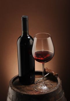 red wine bottle and wine glass on wodden barrel