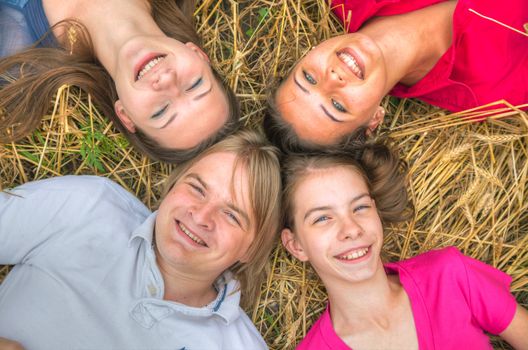 Four young happy people lying on the ground