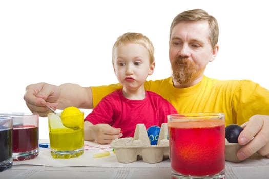 The man and the boy take out an Easter egg from a glass with a paint 