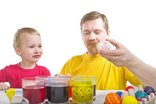 Man show to boy one chiken egg with red drawing