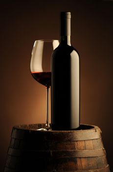 red wine bottle and wine glass on wooden barrel