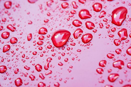 Crystal clear water drops over red background