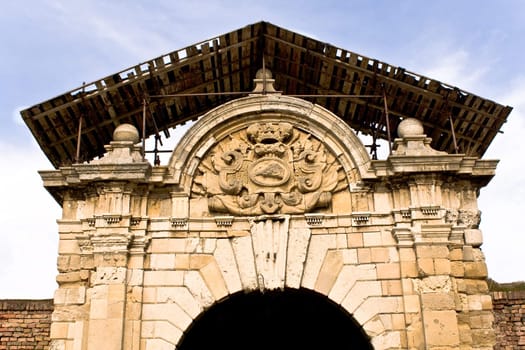 Ancient triumphal arch under reconstruction on blue sky