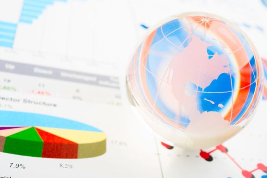 Global year report with glass globe and pen