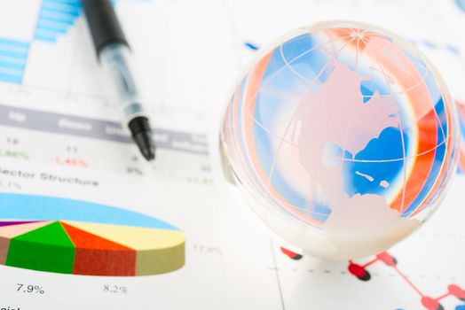 Global year report with glass globe and pen