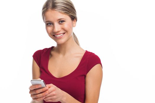 Smiling woman writing a message on her phone, on white