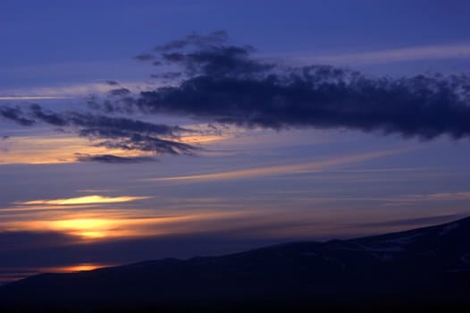 Cloudy sky and mountains on sunset