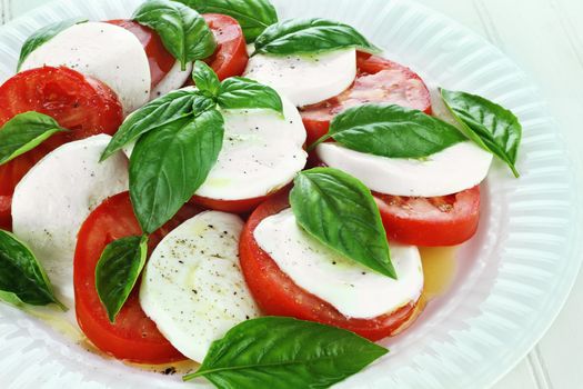 Delicious fresh Caprese Salad on a white dish.