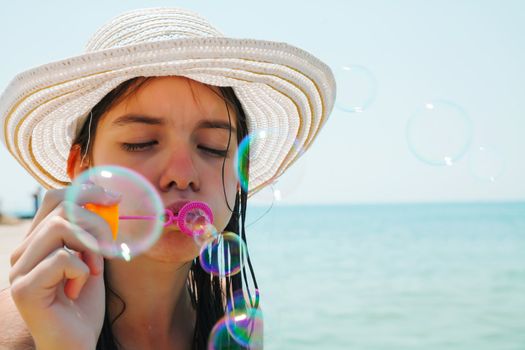 Teen girl blowing bubbles at sea shore