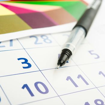 calendar, colored diagram and black pen .