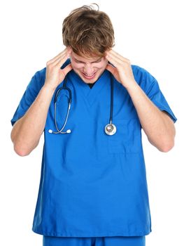 Nurse / doctor headache and stress. Stressed young male medical professional in blue scrubs touching head in pain. Isolated on white background.