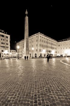 An empty and deserted cobble stone piazza in Rome at night.