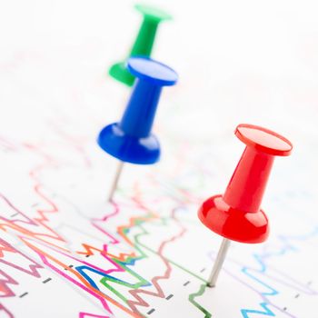 Close-up of red, blue and green pins on graphic