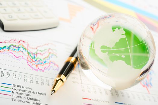 Global year report with glass globe and pen